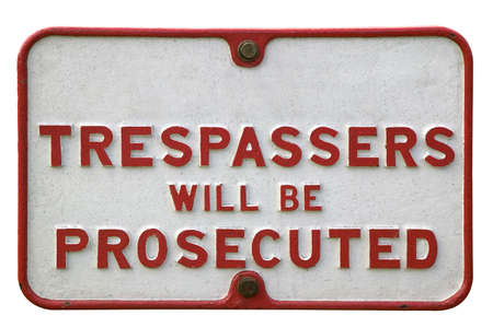 Old metal 'trespassers' sign, isolated on white.の写真素材