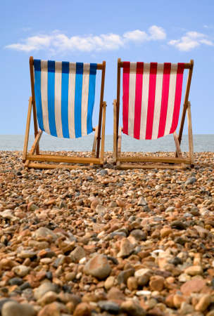 Two deckchairs on a pebble beach, low perspective.の写真素材