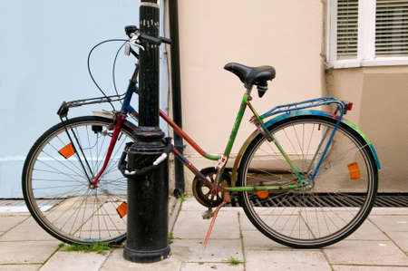 Colourful old bicycle chained to a lampost.の写真素材