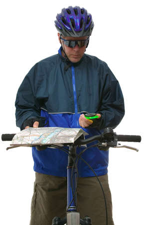 Mountain bike rider reading a map and compass. Isolated on white.の写真素材