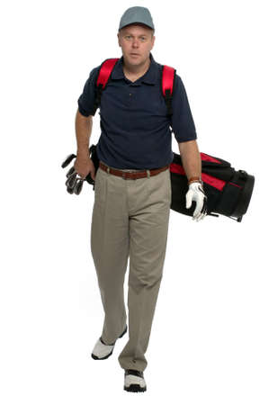 Male golfer walking along carrying his bag.の写真素材
