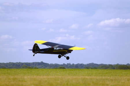 Single propeller light aircraft flying low to the ground.