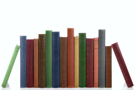 Old books in a row, all hardbacks some with leather covers. Isolated on white with slight shadow.の写真素材
