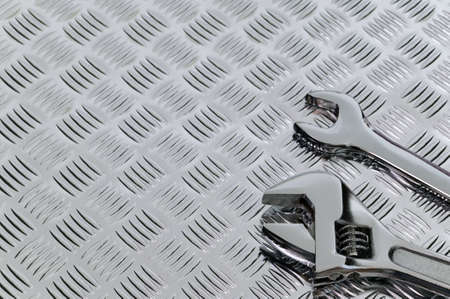 Mechanical image of two spanners on a checkerplate background.の写真素材
