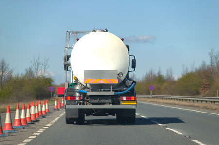Rear view of a fuel tanker driving along a dual carriagewayの写真素材