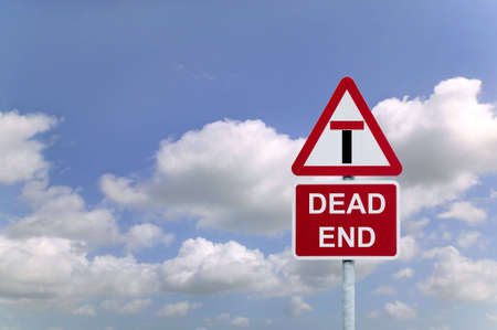 Concept image of a signpost for a Dead End againsta blue cloudy sky.の写真素材