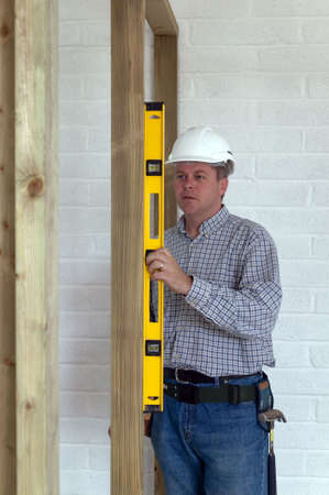 Carpenter checking a timber frame is square and level