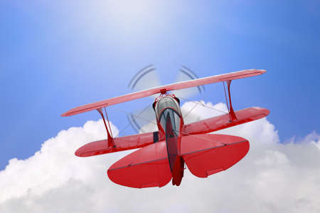 A red biplane flying high above the clouds towards the sun, concept image for the saying Flying highの写真素材