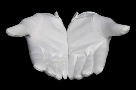 Open hands palms up in white gloves, isolated on a black background.の写真素材