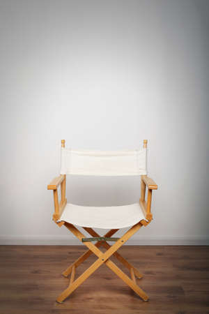 One chair on a wooden floor illuminated with a single light sourceの写真素材