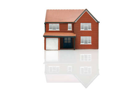 A model house isolated on a white background with reflectionの写真素材