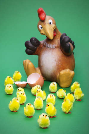 Lots of little toy chicks and a shocked parent, focus is on the little guy at the front.の写真素材