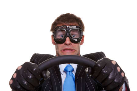 Businessman in driving gloves and goggles with a look of panic on his face, isolated on white background.の写真素材