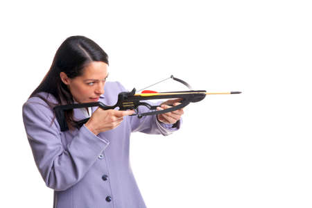 Businesswoman in a suit shooting an arrow from a crossbow as she aims at the target, isolated on a white background.の写真素材