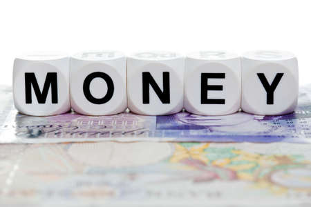 Money spelled in letter cubes on a twenty and ten pound note.の写真素材