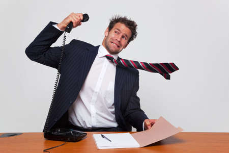 Businessman getting a phone call from an angry person shouting down the line.の写真素材