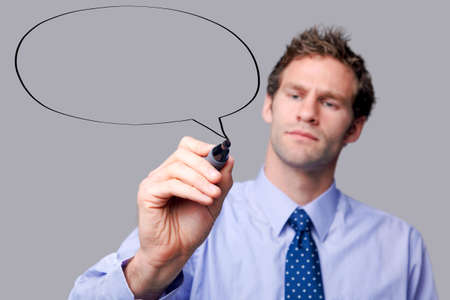 Businessman drawing a speech bubble on a glass screen, add your own text. The background is a uniform color all over so you can increase the copy space easily. Focus is on his hand and pen.の写真素材