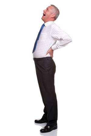 A mature businessman with his hands on his hips as he yawns, isolated on a white background.の写真素材
