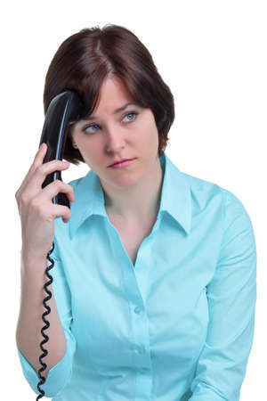 A woman on the telephone who has been put on hold, isolated on a white background.の写真素材