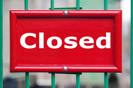 Painted red sign on a gate with the word Closed blurred background.の写真素材
