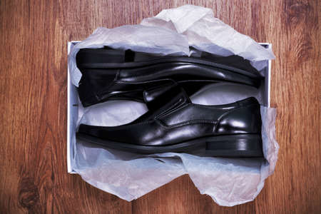  a pair of new mens shoes in a shoe box on rustic wooden floorの写真素材