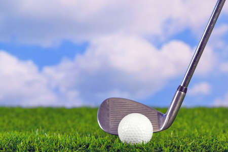 Photo of a golf iron club behind the ball on the fairway.の写真素材