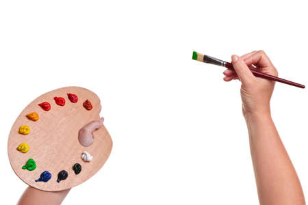 a female artists hands holding a paint brush and palette, isolated on a white background, insert your own image or text.の写真素材