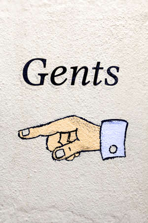 Photo of a Gents sign with a finger pointing the way.の写真素材