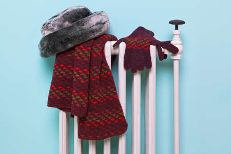 Photo of a womans hat, scarf and gloves drying on an old traditional cast iron radiator, good image for winter related themes.の写真素材