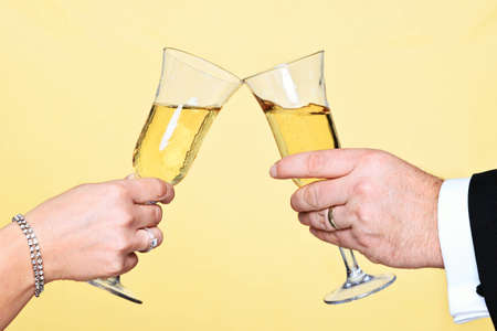 Photo of a man and womans hands toasting with a glass of champagneの写真素材