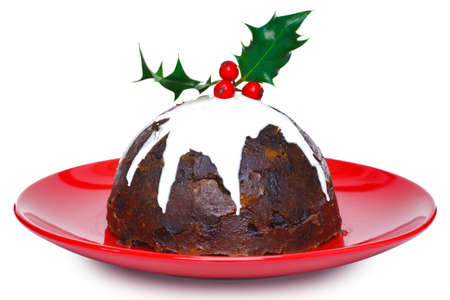 Photo of a steamed Christmas pudding with cream and holly on top isolated on a white background. Slight motion blur on the cream.の写真素材
