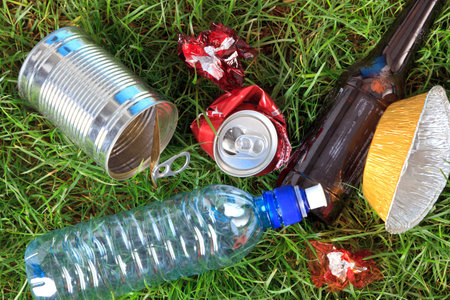 Photo of litter on grass, bottles, cans and wrappers.の写真素材