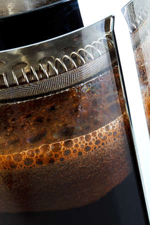 Close up photo of a Cafetiere with freshly brewed coffee inside, this is also know as a French press, Coffee plunger, Coffee press or Caffettiera.の写真素材