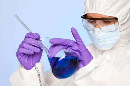 Photo of a biochemist lab technician holding a flask of chemicals and a glass rodの写真素材