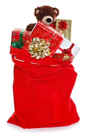 Red Christmas sack full of gift wrapped presents, isolated on a white backgroundの写真素材