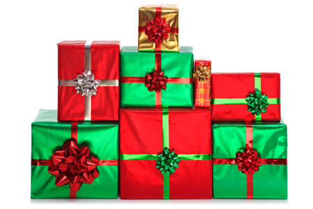 A group of gift wrapped presents in bright shiny wrapping paper with bows and ribbons, isolated on a white background. の写真素材