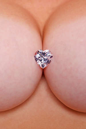 A heart shaped diamond in a womans cleavage.の写真素材