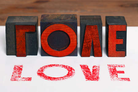 The word LOVE printed on white paper with old wooden letterpress blocks.の写真素材