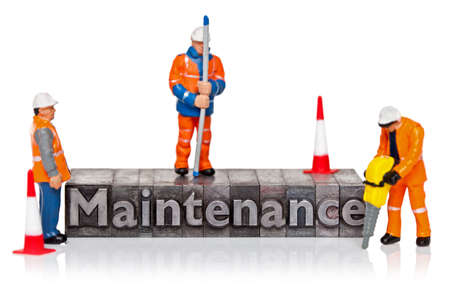 Hand painted miniature workmen figurines and the word Maintenance in old metal letterpress isolated on a white background.の写真素材