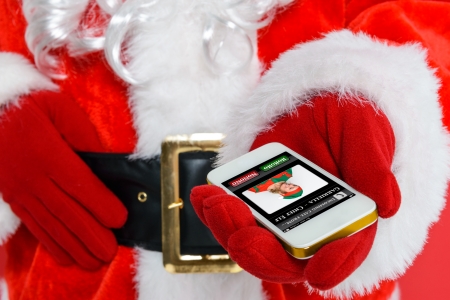 Santa Claus or Father Christmas getting a phone call from his Chief Elf on Christmas Eve.の写真素材