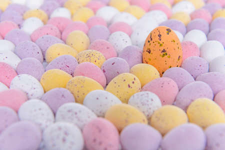 Lots of mini candy covered chocolate Easter eggs with one standing out from the crowd.