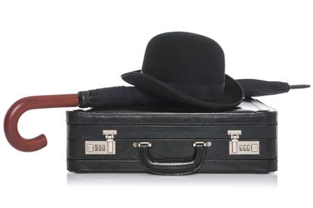 Black leather briefcase with bowler hat and umbrella, isolated on a white background.の写真素材