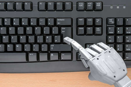 Robot hand typing on a computer keyboard.の写真素材