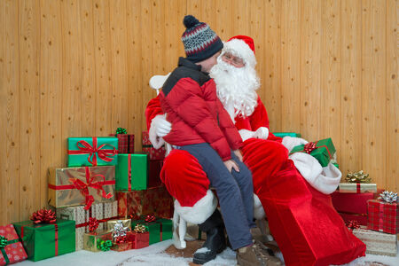 A boy visiting Santa in his grotto at Christmas.の写真素材