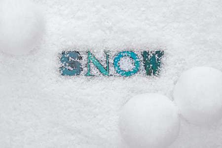 The word SNOW made from wooded letterpress letters on a snow backgroundの写真素材