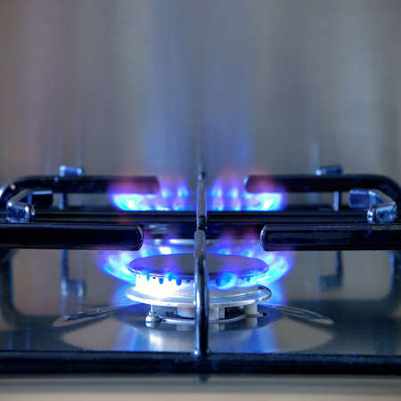 Two gas rings alight on a modern brushed steel hob.