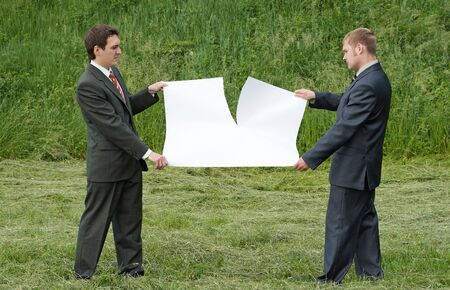 businessmen tearing sheet of paperの写真素材