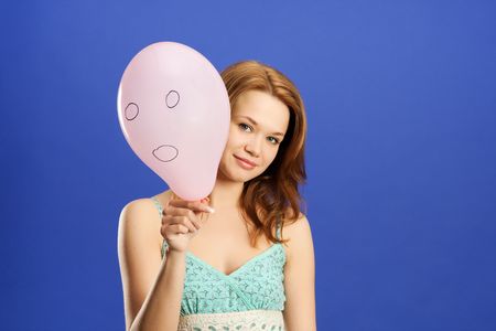 pretty girl holding pink surprised balloonの写真素材