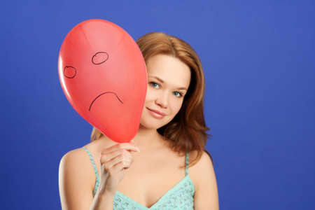pretty girl holding red angry balloonの写真素材
