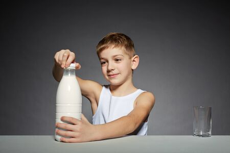 Boy opening bottle of milkの写真素材